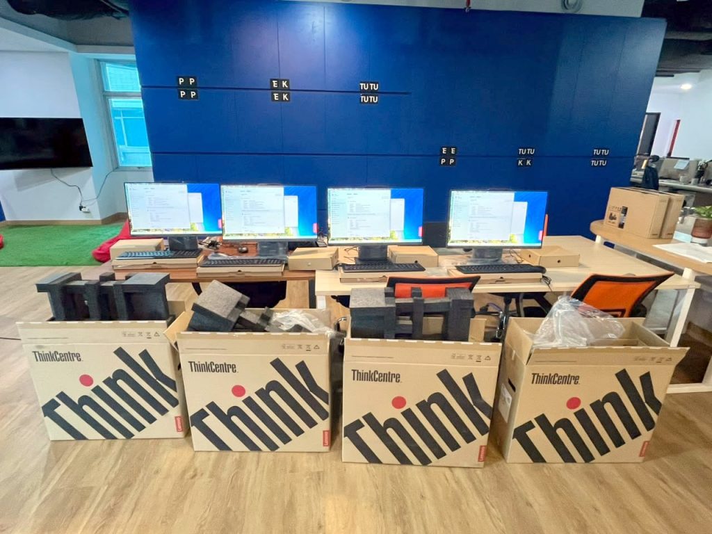 Empat PC all-in-one Lenovo ThinkCentre menyala di meja kerja